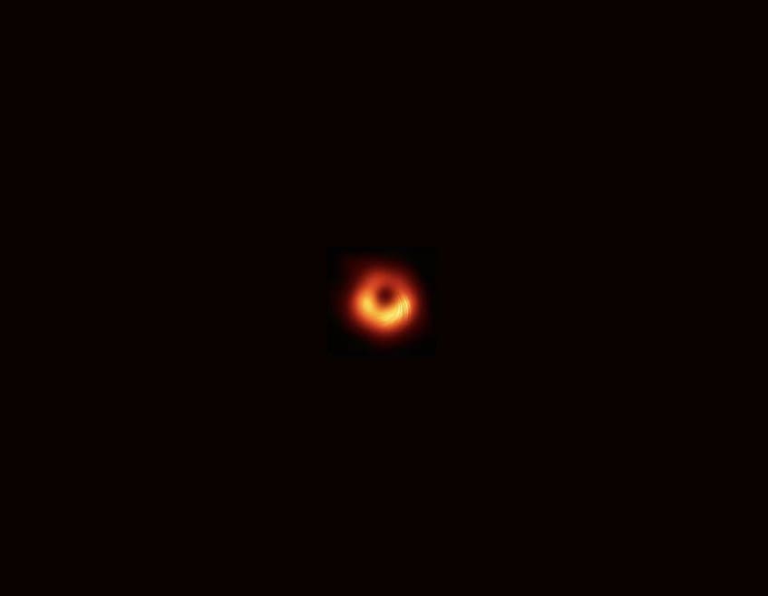 Here's a concise alt tag for the image: `Black hole image from space`