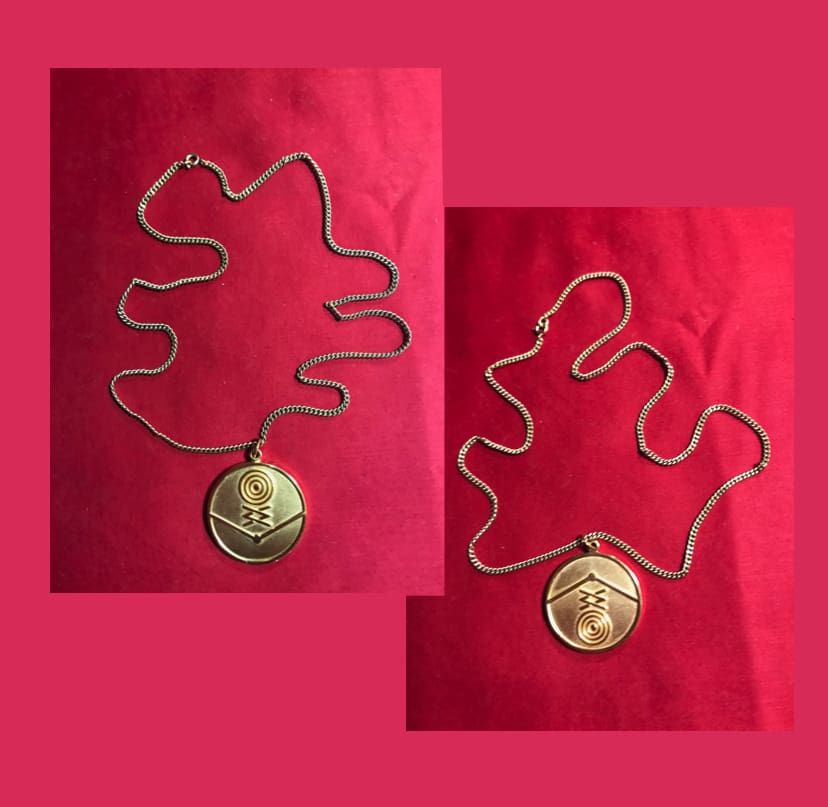Gold necklace with circular pendant.